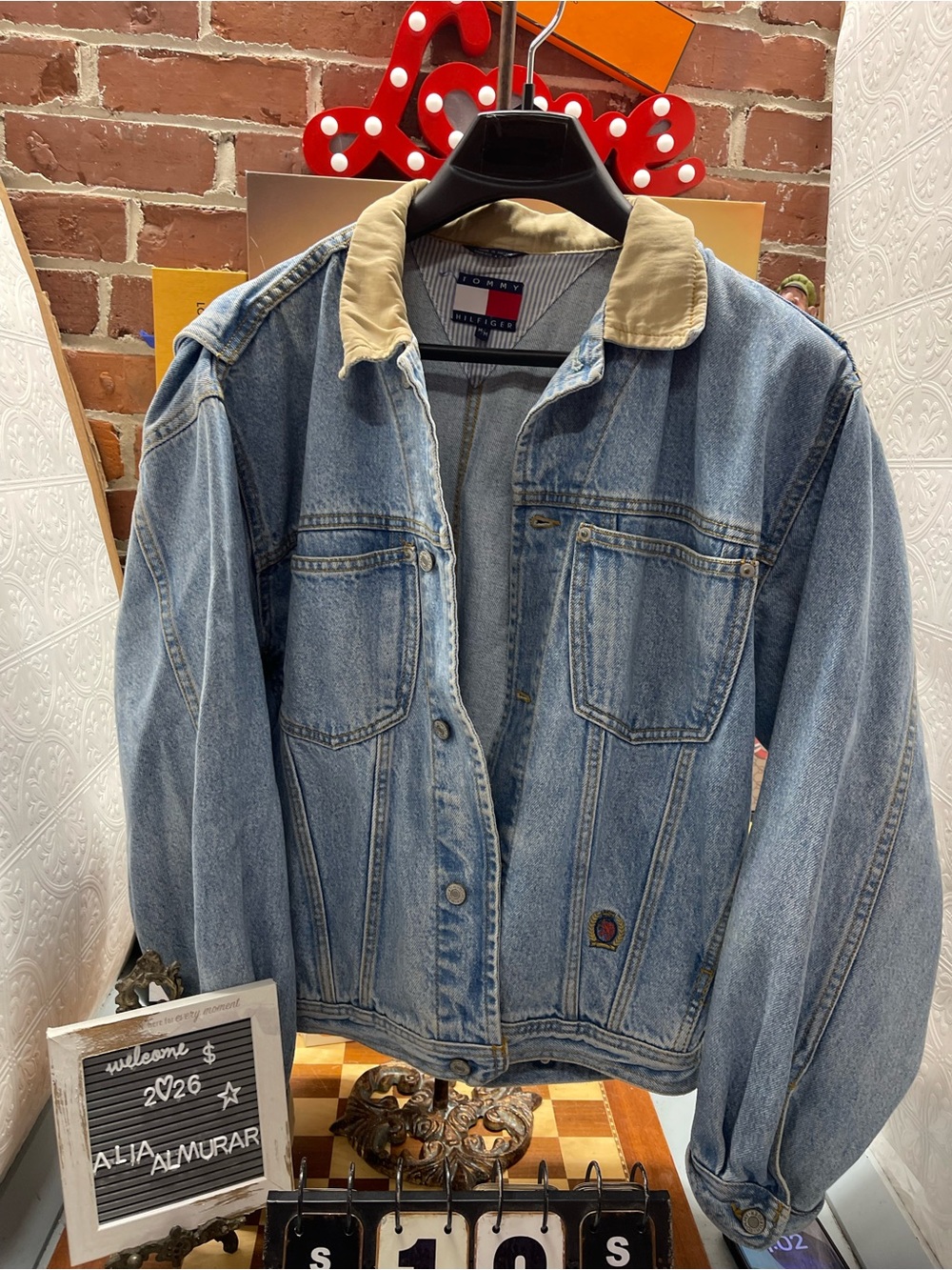 vintage 1990s Tommy Hilfiger light blue denim trucker jacket featuring a contras